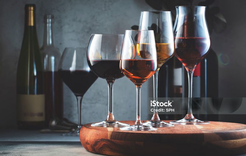 Wine glasses ans bottles assortment. Red, white, rose wines on gray table background. Wine bar, shop, tasting concept